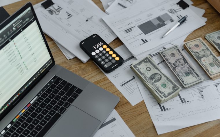 Bureau avec documents financiers, argent et calculatrice