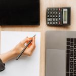 Personne calculant son salaire sur bureau professionnel