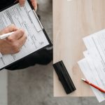 Personne remplissant des formulaires sur presse-papiers