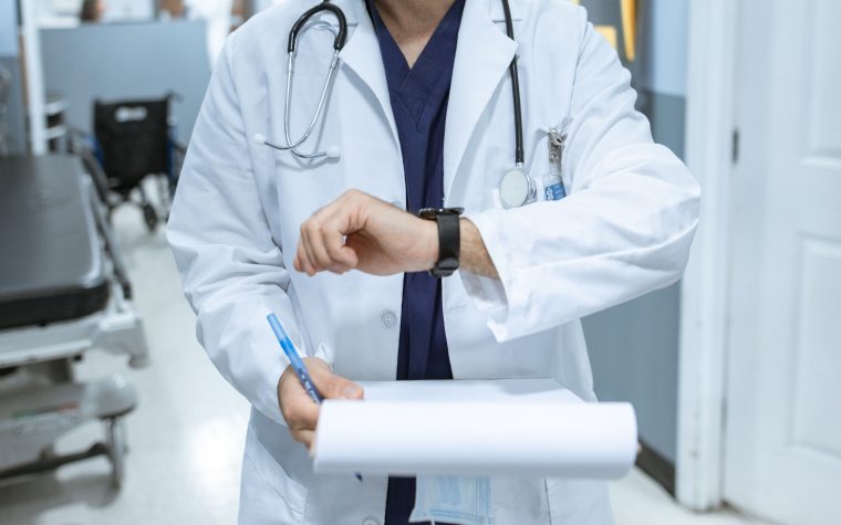 Médecin en blouse blanche consultant sa montre