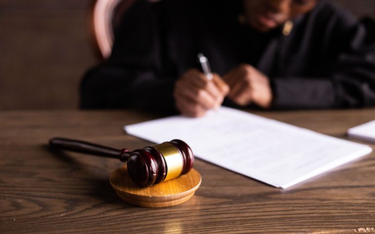Juge signant des documents avec marteau de justice