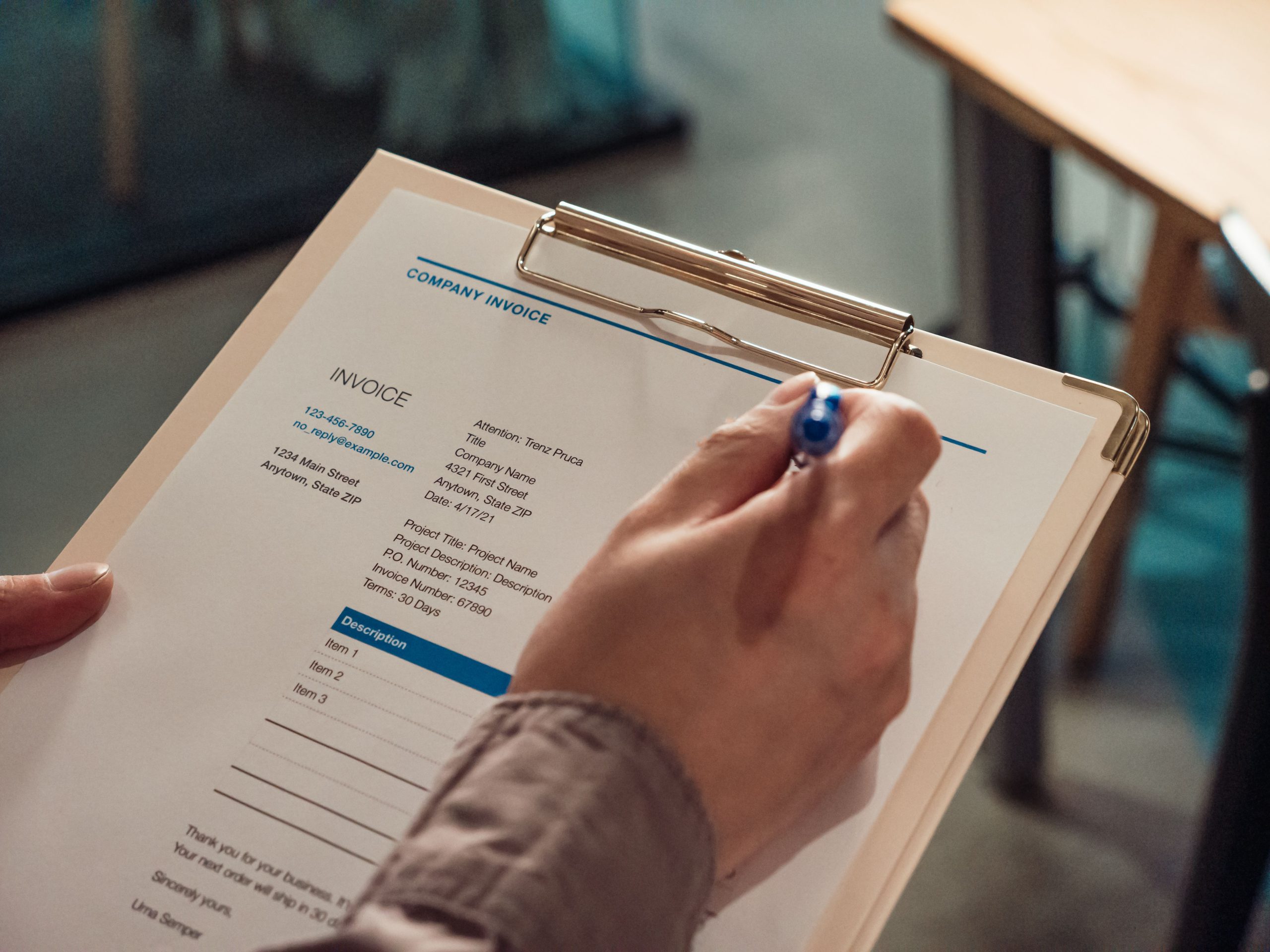 Personne tenant facture entreprise sur presse-papiers