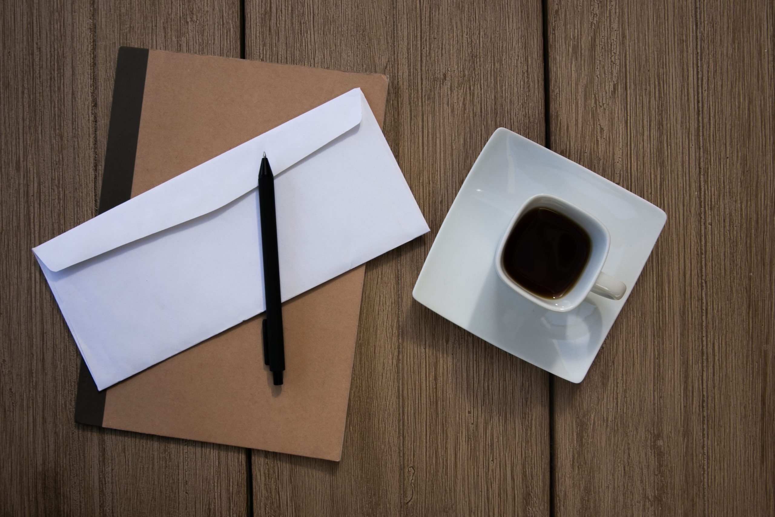 Café, carnet et enveloppe sur table