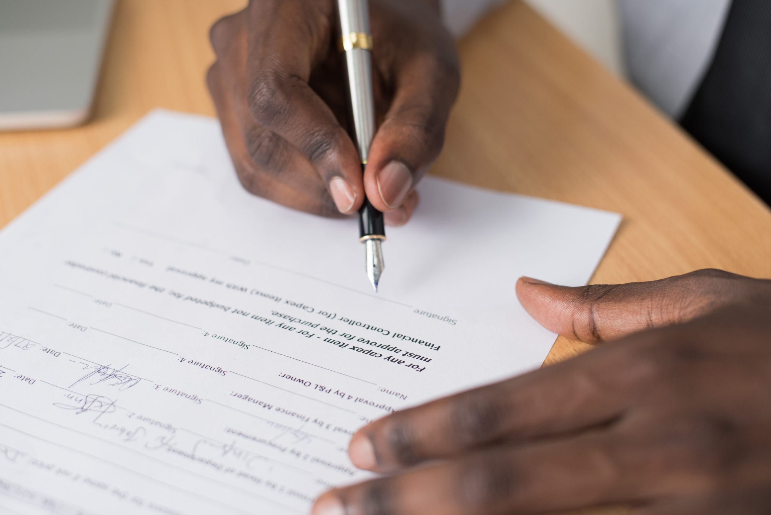 Homme signant un document formel des deux mains