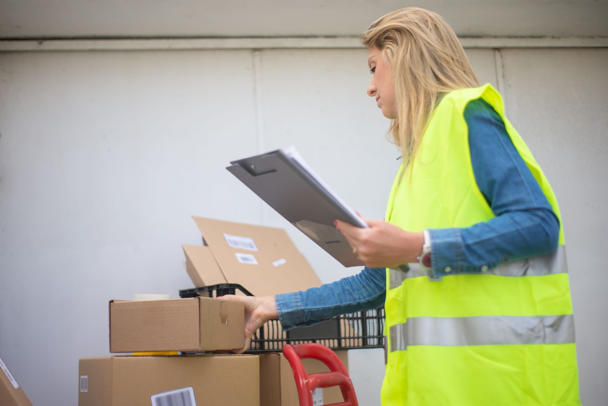 Femme en gilet jaune manipulant des cartons