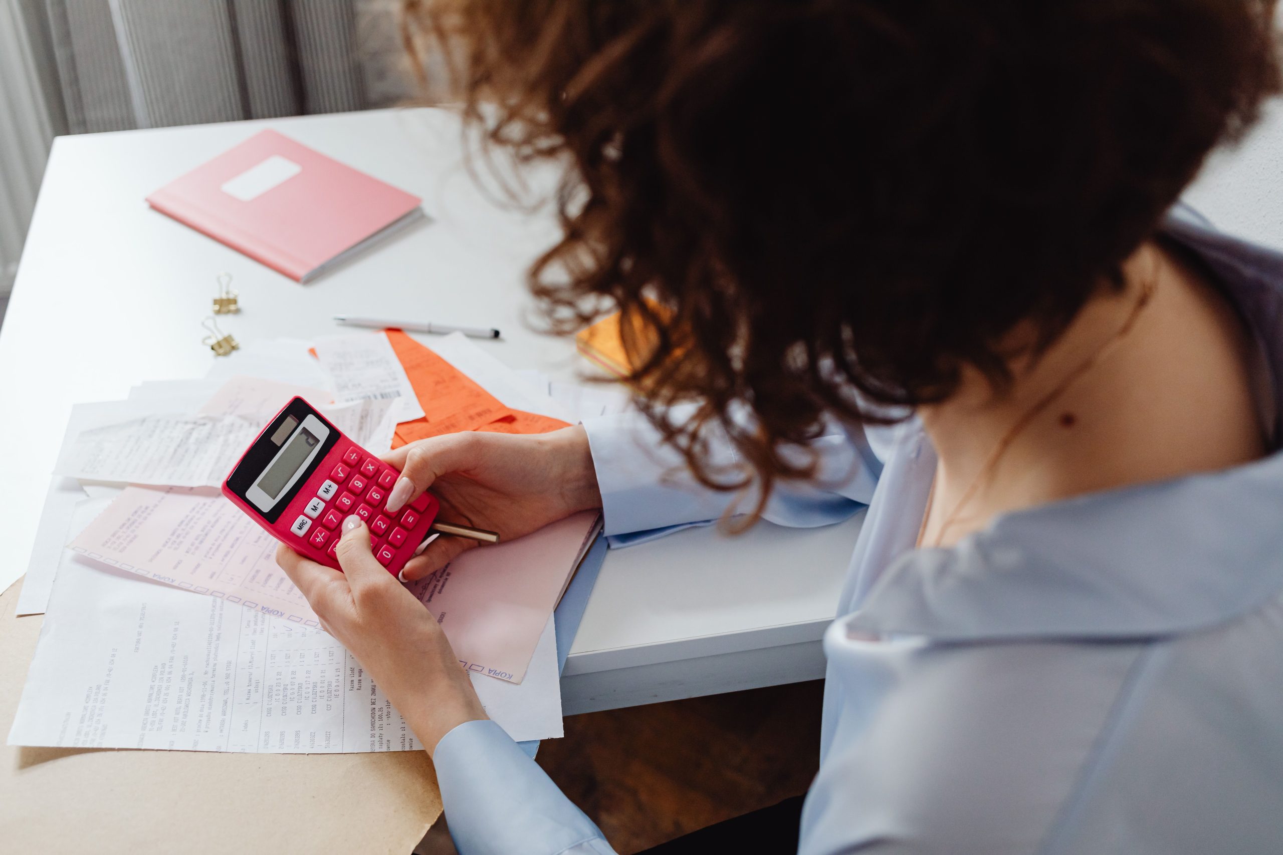 Femme calculant dépenses avec documents bureau
