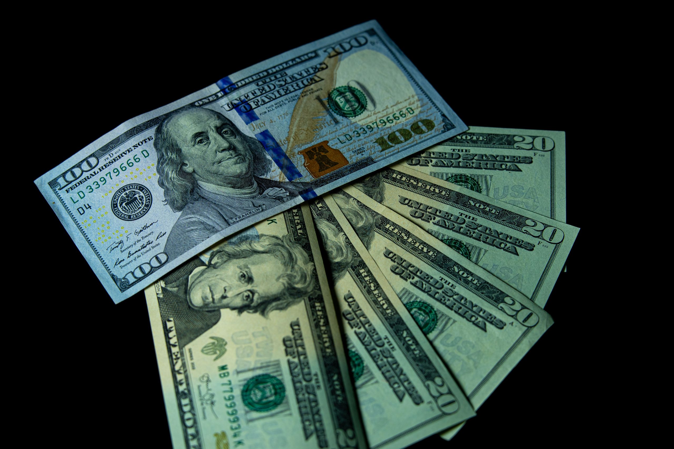 Différents billets USD sur fond noir