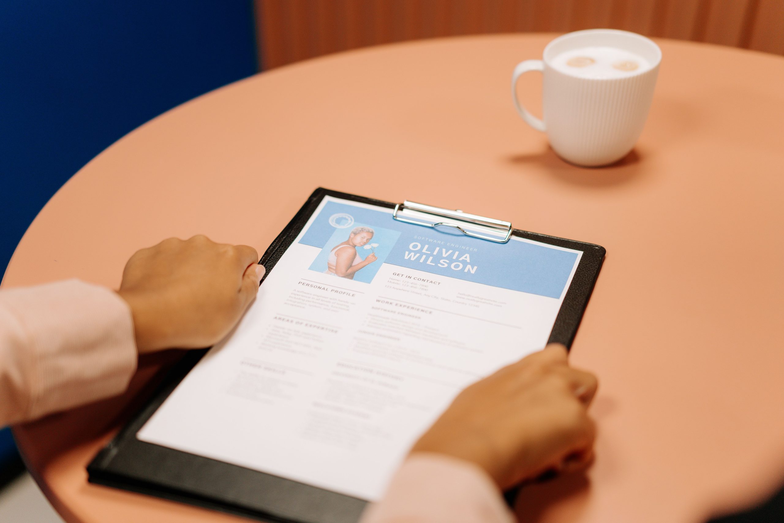 Mains tenant un CV lors d'un entretien d'embauche