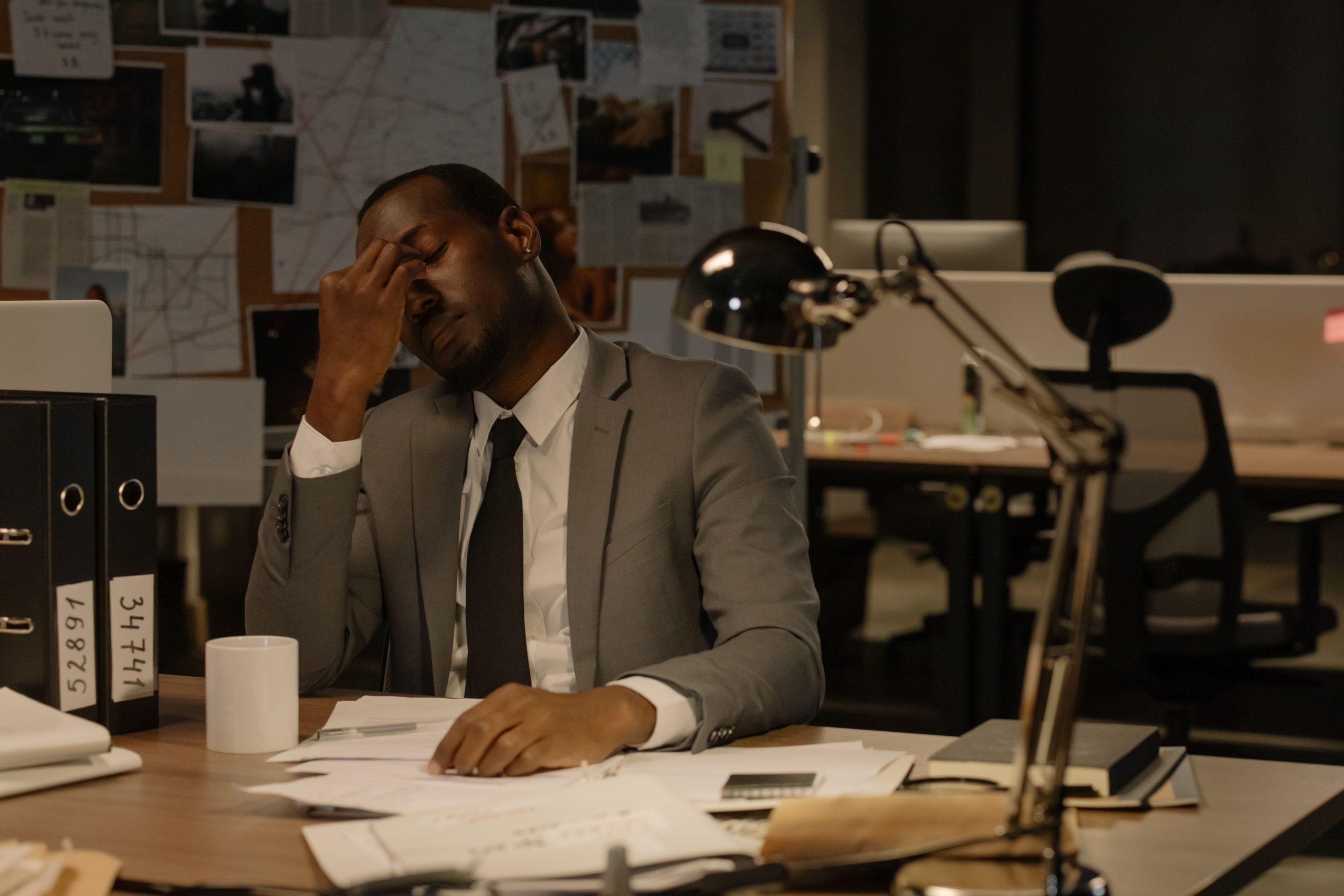 Employé épuisé entouré de documents au bureau