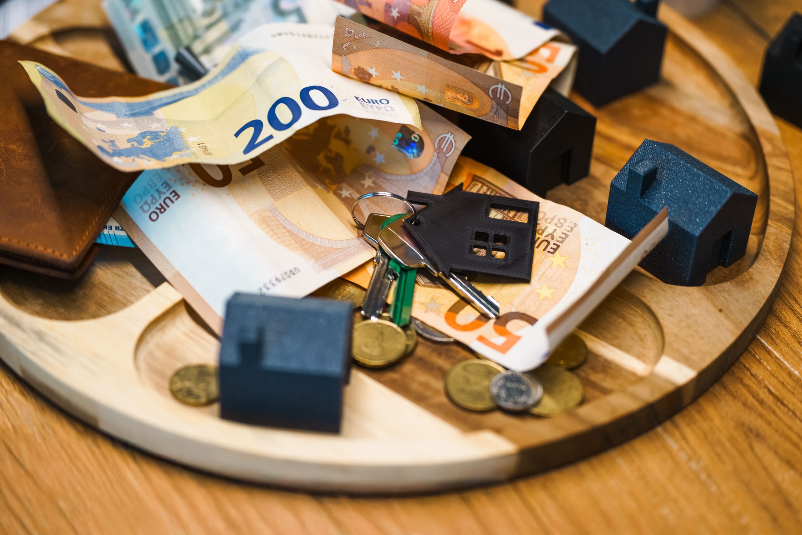 Euros, clés et miniatures maisons représentent finance immobilière