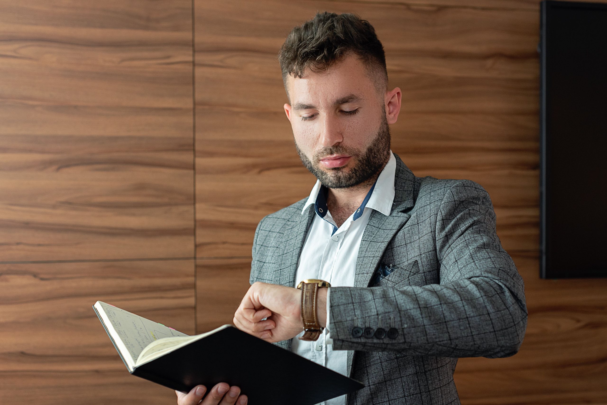 Homme d'affaires consultant sa montre avec carnet