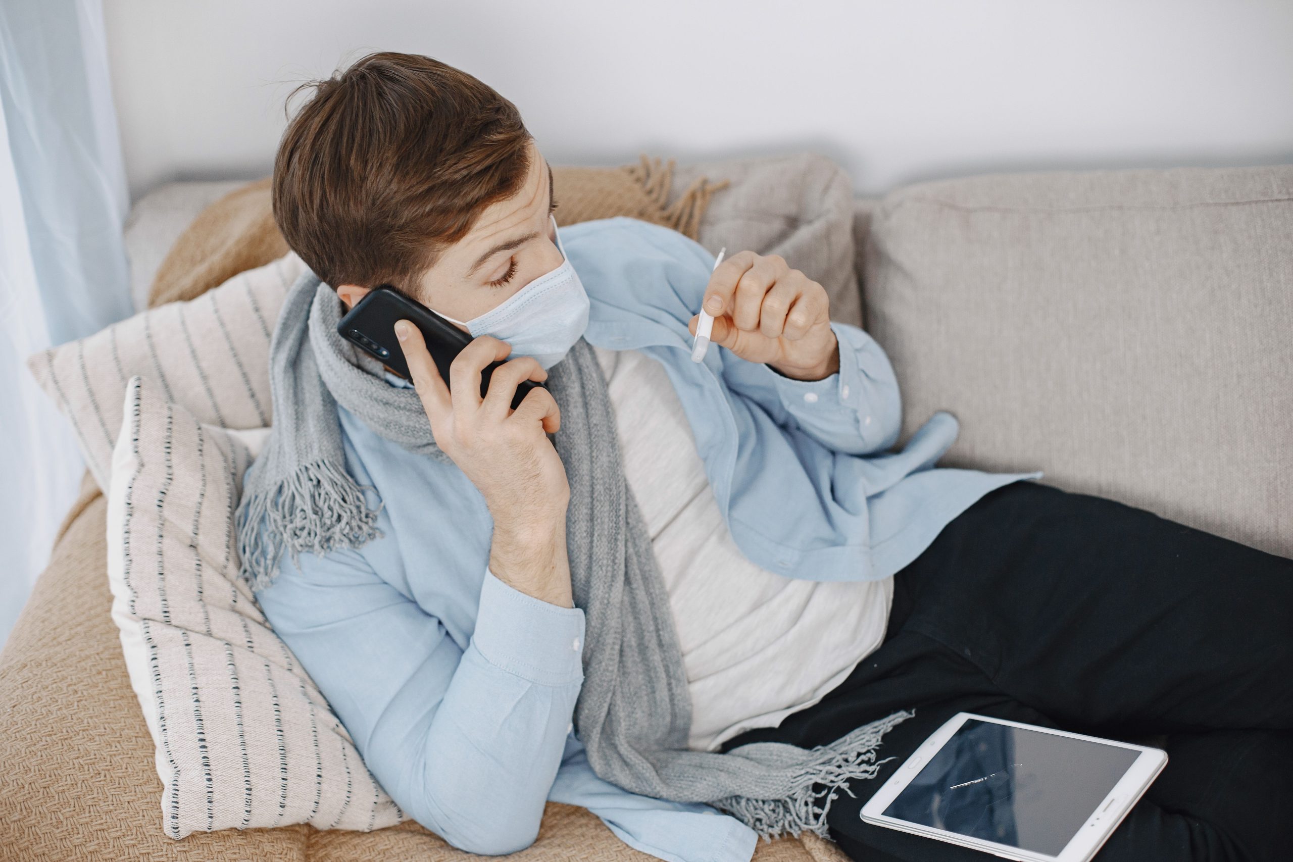 Homme malade téléconsultation téléphone canapé