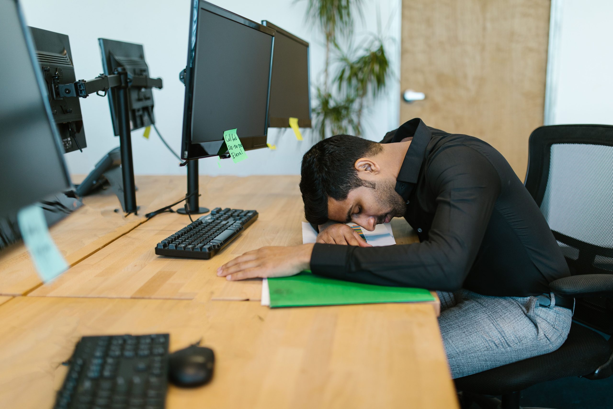 Travailleur fatigué reposant sur son bureau moderne